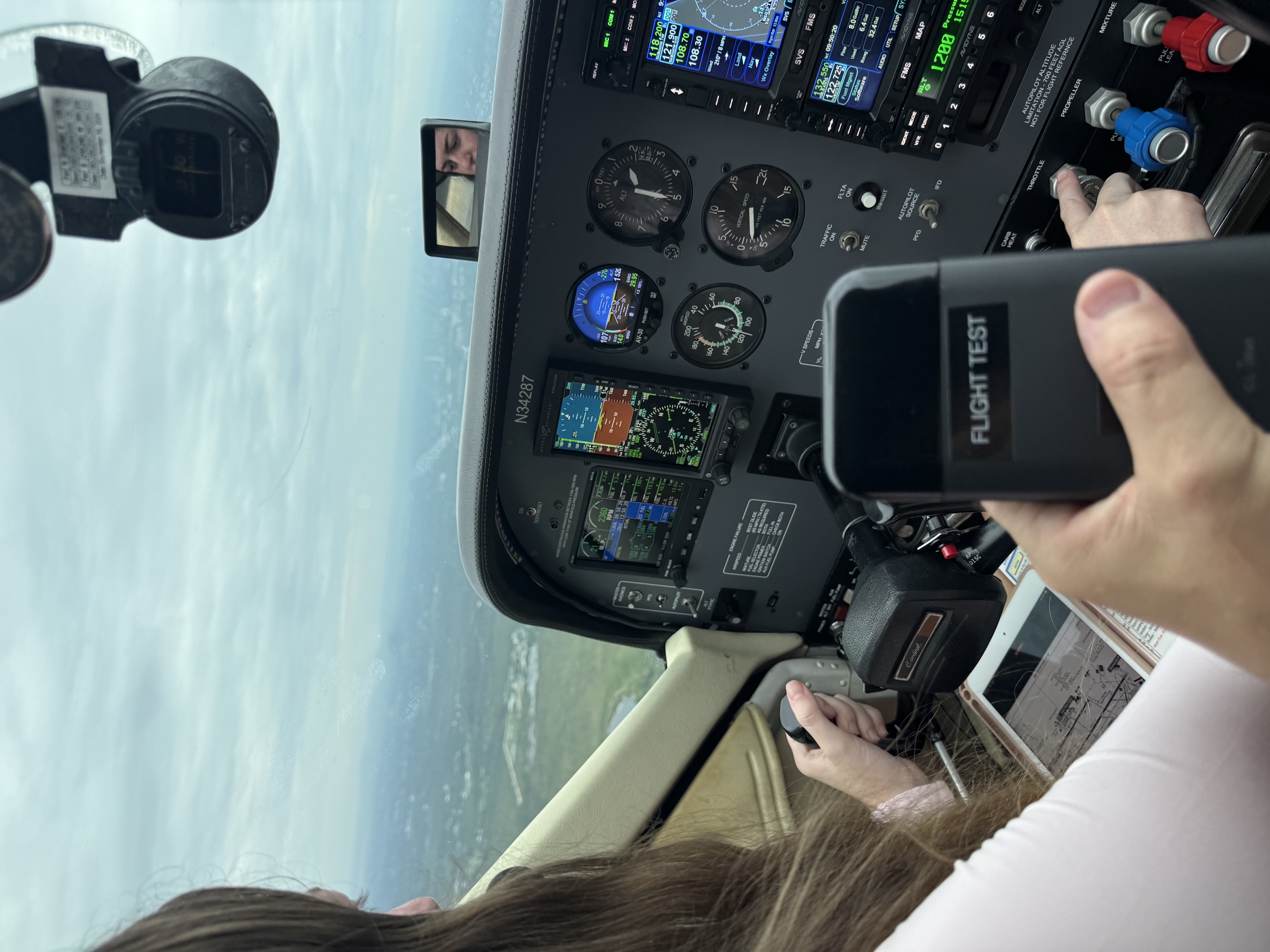 Pilot conducting an in-flight PlaneDrive avionics test in a light aircraft cockpit